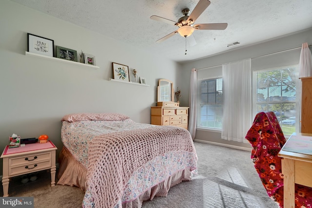 bedroom with a ceiling fan, carpet flooring, a textured ceiling, and visible vents