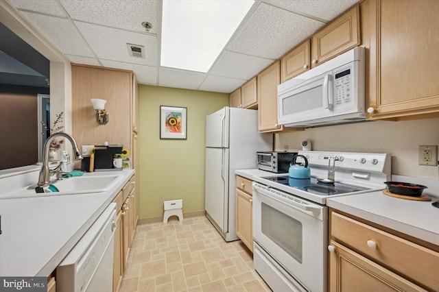 kitchen featuring white appliances, a drop ceiling, light countertops, baseboards, and visible vents