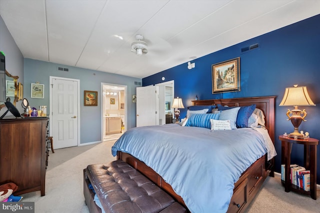 bedroom featuring visible vents, ensuite bath, and light carpet