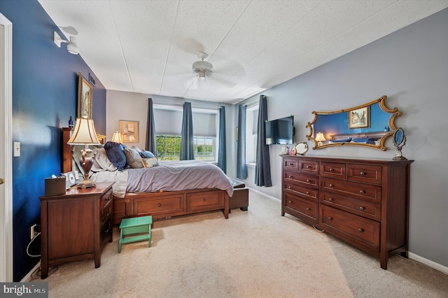 bedroom with baseboards, a ceiling fan, and light colored carpet