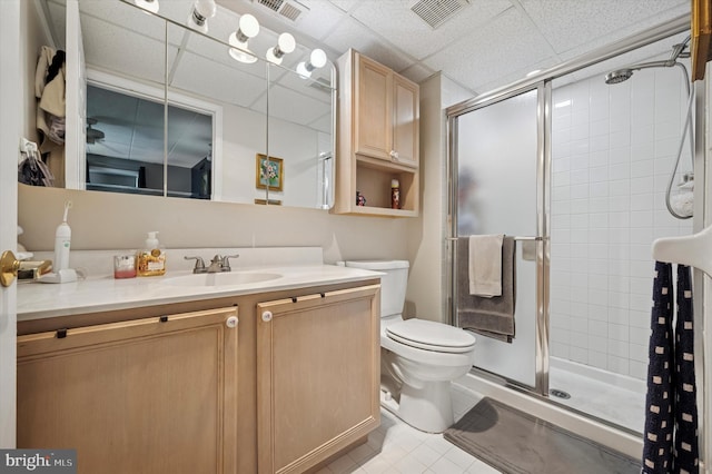 bathroom with tile patterned floors, a shower stall, toilet, vanity, and visible vents