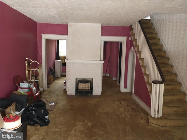 6812 Sprague St, Philadelphia, PA 19119 - unfurnished living room with stairs, a brick fireplace, a textured ceiling, and carpet floors