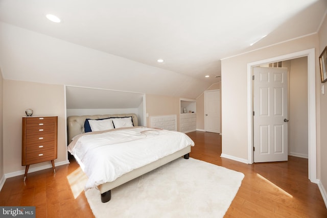 bedroom with recessed lighting, light wood-style floors, baseboards, and vaulted ceiling
