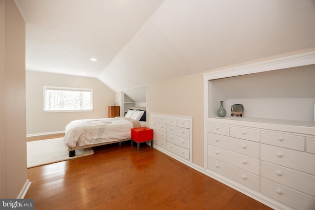 bedroom featuring wood finished floors, baseboards, and lofted ceiling