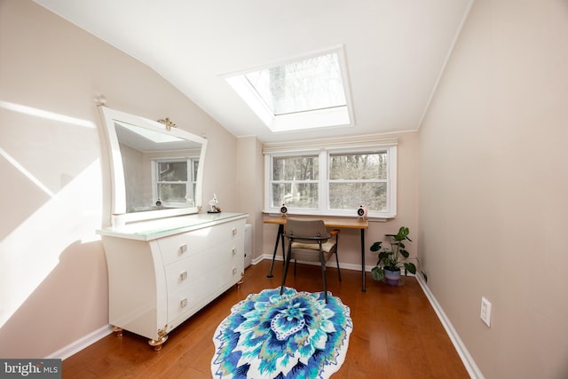 office featuring lofted ceiling with skylight, baseboards, and wood finished floors