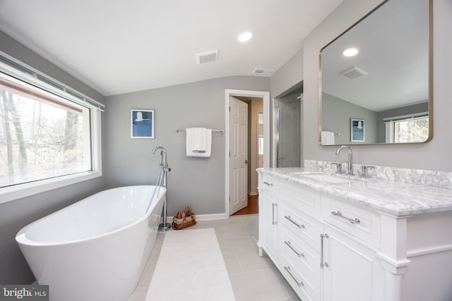 bathroom with visible vents, vanity, and lofted ceiling