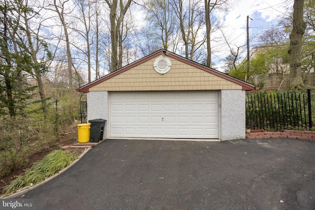 detached garage featuring fence