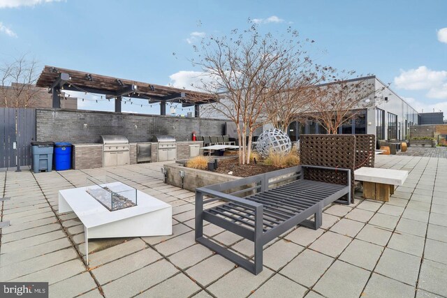 view of patio with an outdoor fire pit, area for grilling, and fence