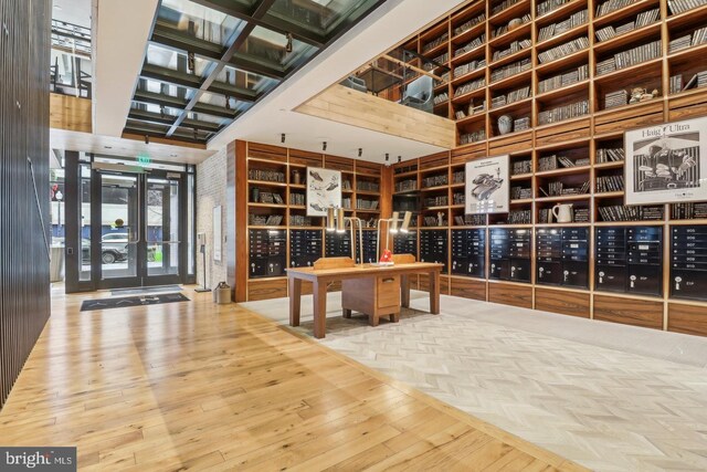 wine area with wood finished floors, mail area, and a towering ceiling
