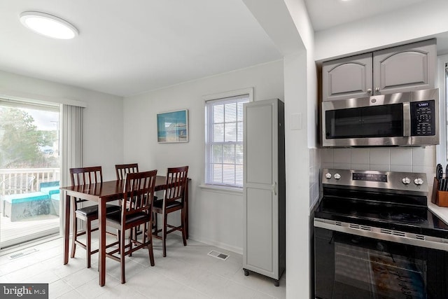 10429 Brighton Rd, Ocean City, MD 21842 - dining space with healthy amount of natural light, light tile patterned floors, and baseboards