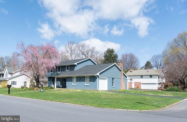 768 Lexington Ave, Hershey, PA 17033 - traditional-style house featuring a front lawn, brick siding, a garage, and a chimney