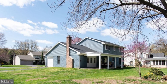 768 Lexington Ave, Hershey, PA 17033 - back of property with a yard, an attached garage, a chimney, brick siding, and driveway
