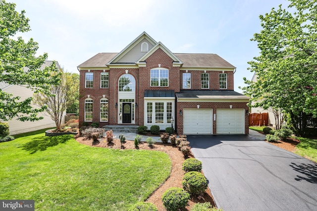 view of front of property featuring driveway, a front yard, a garage, brick siding, and fence