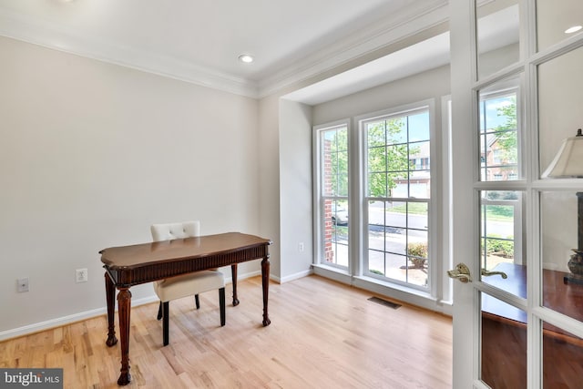 office area with baseboards, ornamental molding, light wood-style flooring, and visible vents
