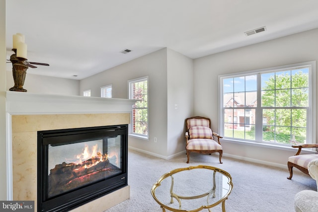 sitting room featuring visible vents, baseboards, plenty of natural light, and a fireplace
