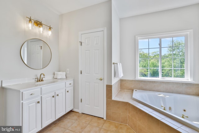 full bath with a jetted tub, vanity, and tile patterned floors