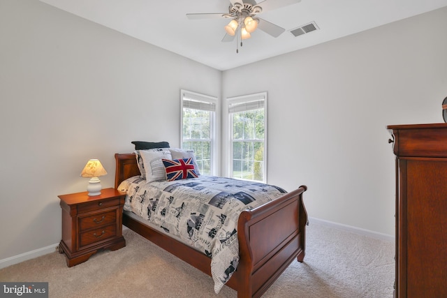 bedroom featuring visible vents, a ceiling fan, baseboards, and light carpet