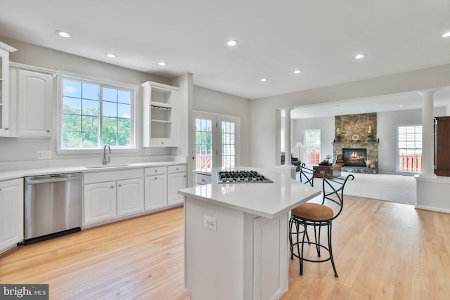 kitchen featuring light wood-style floors, a sink, appliances with stainless steel finishes, and a kitchen island