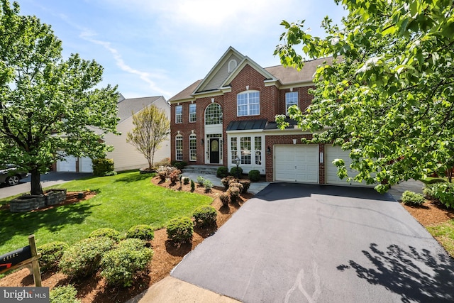 view of front of house featuring a garage, a front yard, driveway, and brick siding