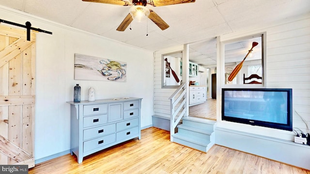 11951 Neale Sound Dr, Cobb Island, MD 20625 - interior space with a barn door, light wood-style floors, baseboards, and ceiling fan