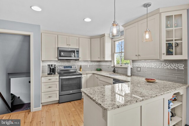 517 Monocacy Hl, Birdsboro, PA 19508 - kitchen featuring a sink, appliances with stainless steel finishes, light wood-type flooring, decorative light fixtures, and a peninsula