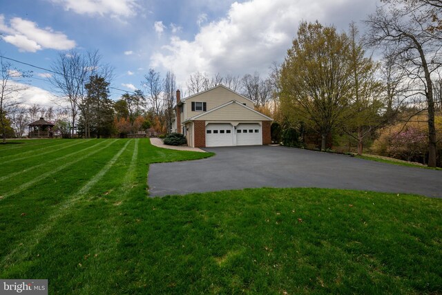 517 Monocacy Hl, Birdsboro, PA 19508 - view of side of property with a chimney, a yard, brick siding, aphalt driveway, and an attached garage