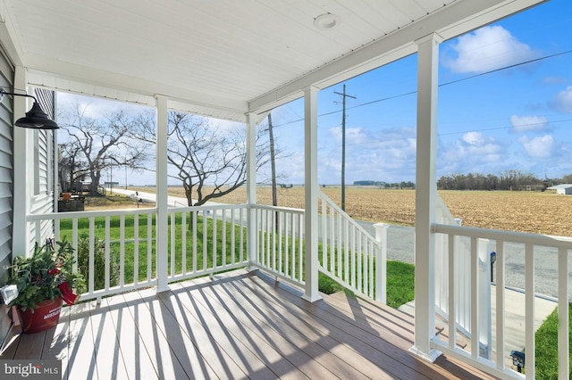 unfurnished sunroom featuring hardwood / wood-style flooring and a rural view