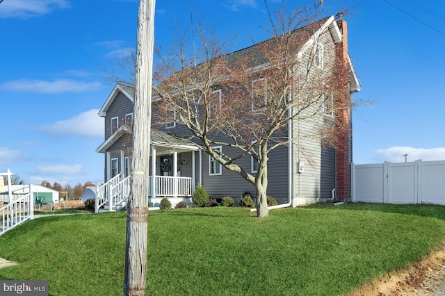 view of front of house with fence, a porch, and a front yard