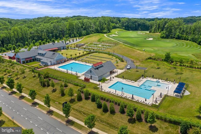 aerial view with view of golf course and a forest view