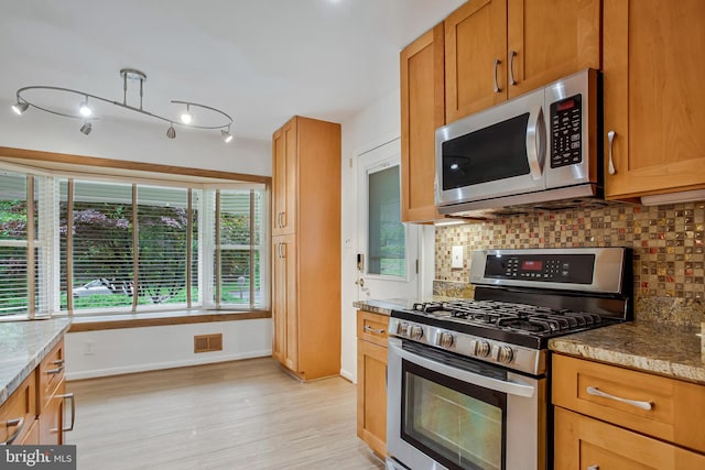 6901 Niles Dr, Laurel, MD 20707 - kitchen featuring stainless steel appliances, decorative backsplash, baseboards, light wood-style flooring, and light stone counters