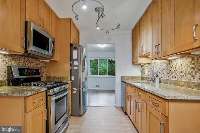6901 Niles Dr, Laurel, MD 20707 - kitchen with stainless steel appliances, a sink, light wood-type flooring, tasteful backsplash, and light stone countertops