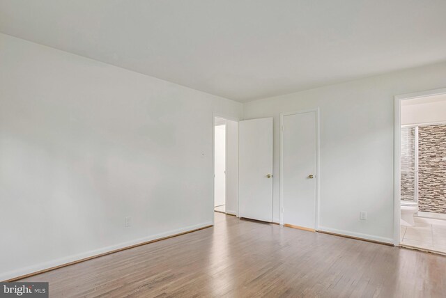 6901 Niles Dr, Laurel, MD 20707 - unfurnished bedroom featuring wood finished floors, connected bathroom, and baseboards