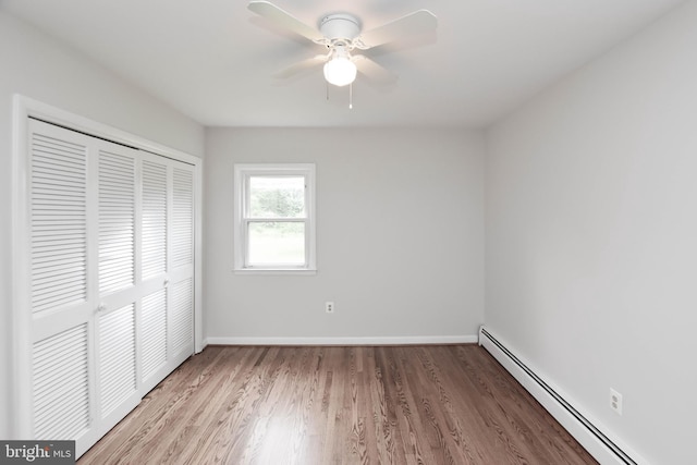 19468 Youngs Cliff Rd, Sterling, VA 20165 - unfurnished bedroom with a baseboard heating unit, a closet, wood finished floors, and baseboards