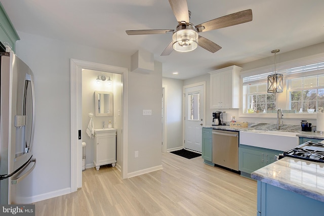 20938 Olen Mattingly Rd, Avenue, MD 20609 - kitchen featuring light stone countertops, stainless steel appliances, a ceiling fan, a sink, and light wood-style floors