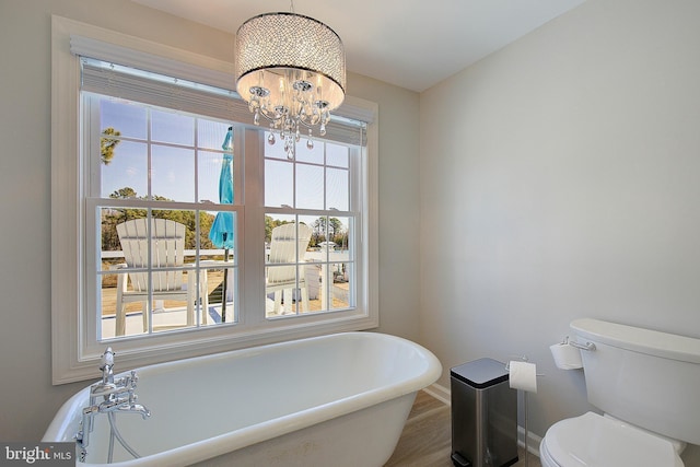 20938 Olen Mattingly Rd, Avenue, MD 20609 - bathroom with an inviting chandelier, toilet, baseboards, a soaking tub, and wood finished floors
