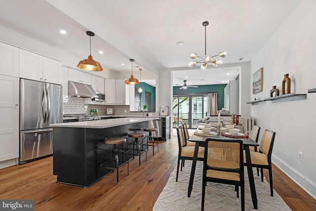 dining space featuring light wood-style flooring, a chandelier, ceiling fan, recessed lighting, and baseboards