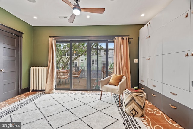 living area with radiator heating unit, recessed lighting, and a ceiling fan