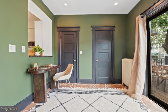entrance foyer with radiator heating unit, baseboards, and recessed lighting