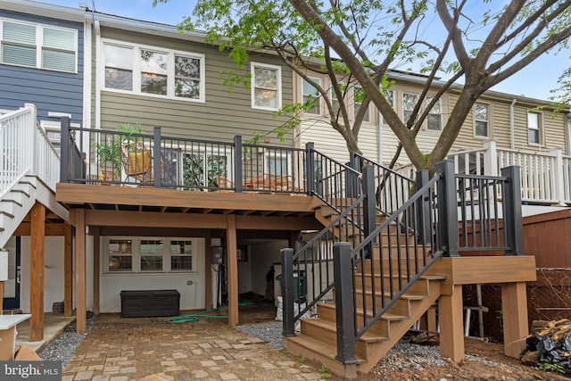 rear view of property featuring a deck, a patio, and stairs