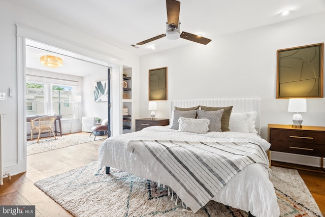 bedroom with wood finished floors, radiator, and a ceiling fan
