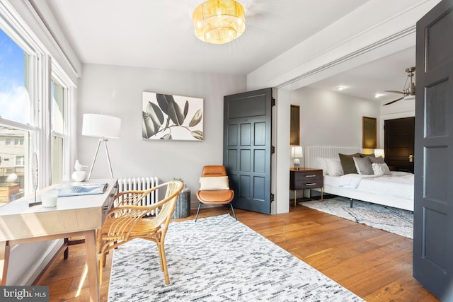 office space featuring radiator heating unit, light wood finished floors, and a chandelier