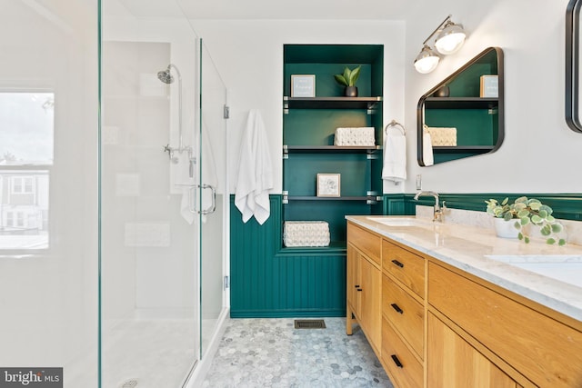 full bathroom with a shower stall and double vanity