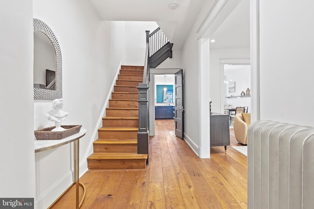 foyer entrance featuring light wood-style floors, stairs, and baseboards