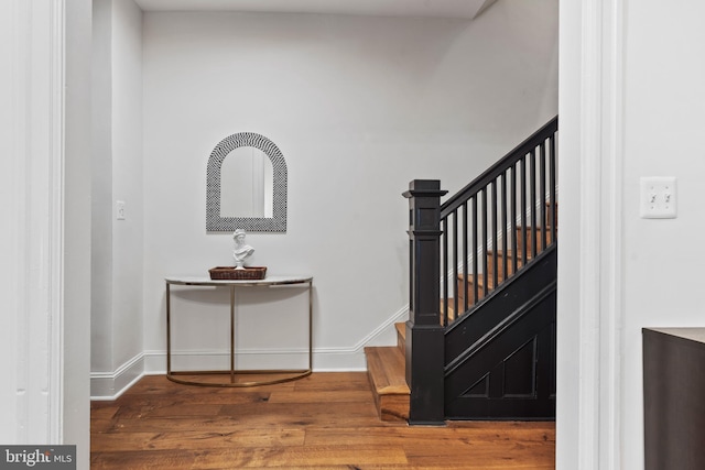 stairway with wood finished floors and baseboards