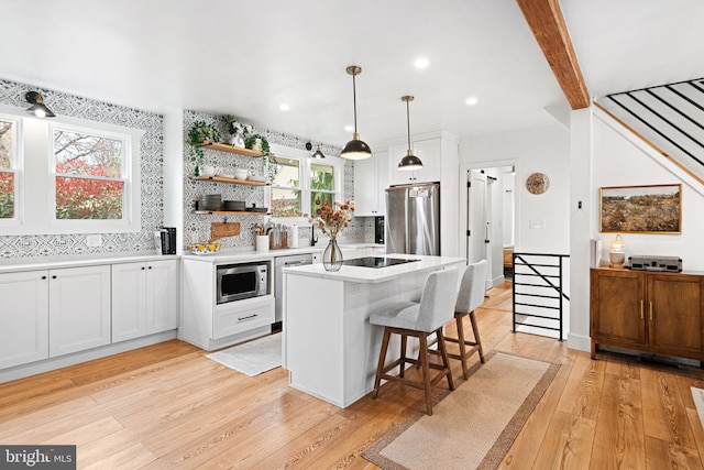307 Kendall Blvd, Oaklyn, NJ 08107 - kitchen featuring tasteful backsplash, appliances with stainless steel finishes, a kitchen bar, white cabinetry, and light wood finished floors