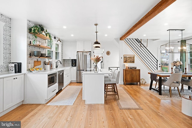 307 Kendall Blvd, Oaklyn, NJ 08107 - kitchen featuring a breakfast bar, a center island, backsplash, open shelves, and appliances with stainless steel finishes