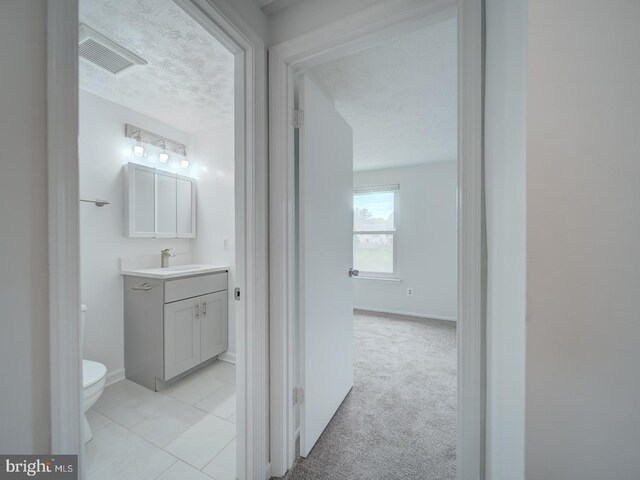 1566 Lodge Pole Ct, Annapolis, MD 21409 - corridor with a textured ceiling, visible vents, a sink, baseboards, and light tile patterned flooring