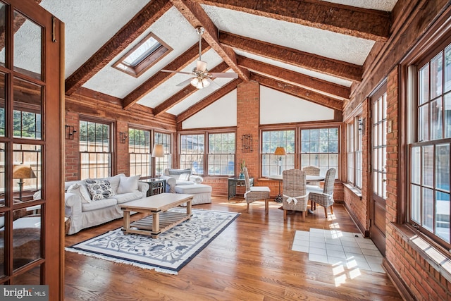 living room featuring plenty of natural light, a textured ceiling, wood finished floors, and ceiling fan