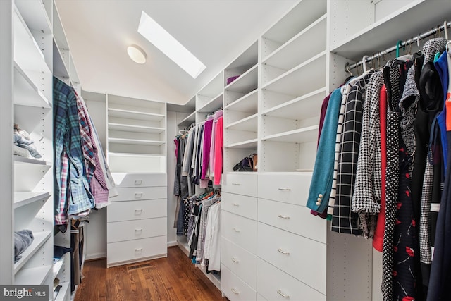 spacious closet featuring wood finished floors, visible vents, and lofted ceiling with skylight