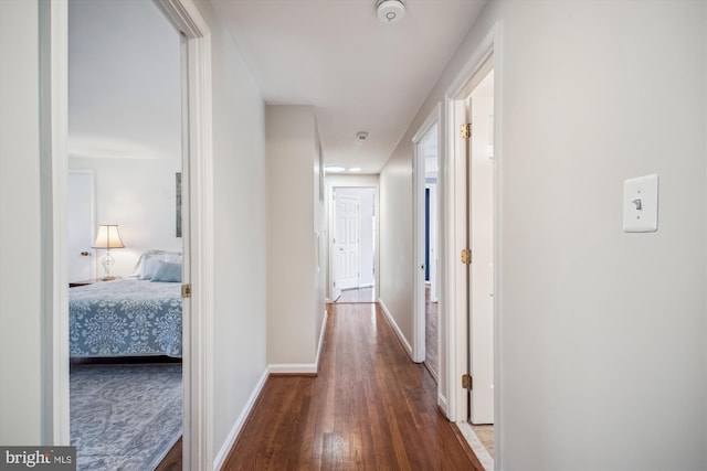 corridor with wood finished floors and baseboards